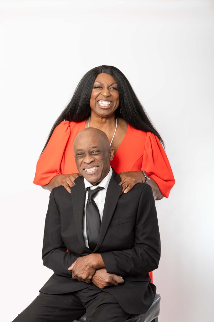 Denise Carter and her husband Wills posing together in formal attire during a studio brand photoshoot.