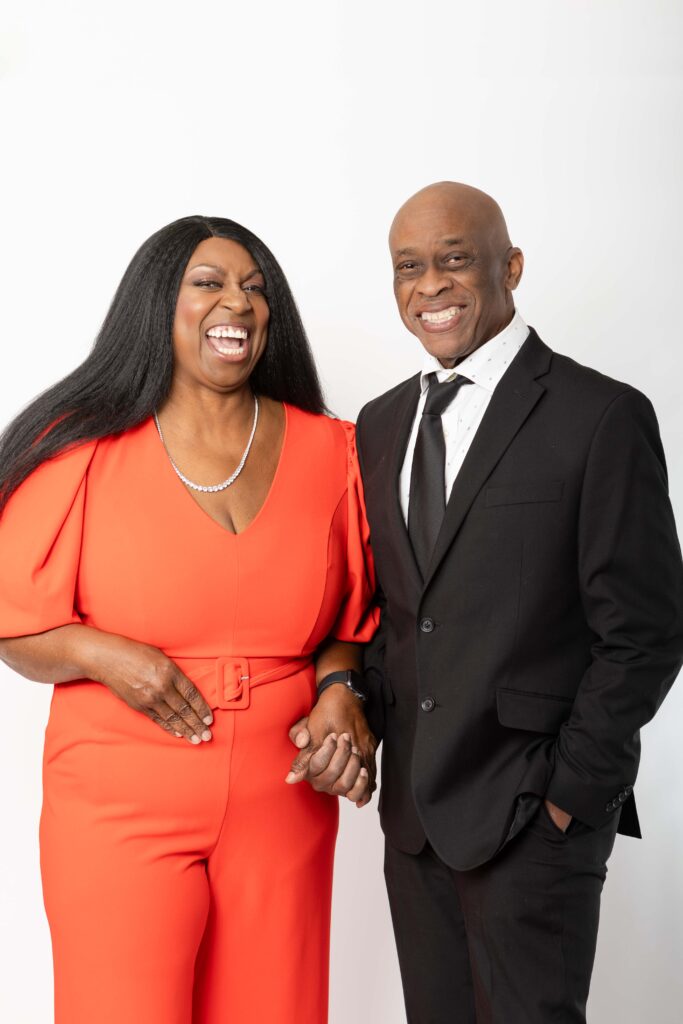 Denise Carter and her husband Wills posing together in formal attire during a studio brand photoshoot.