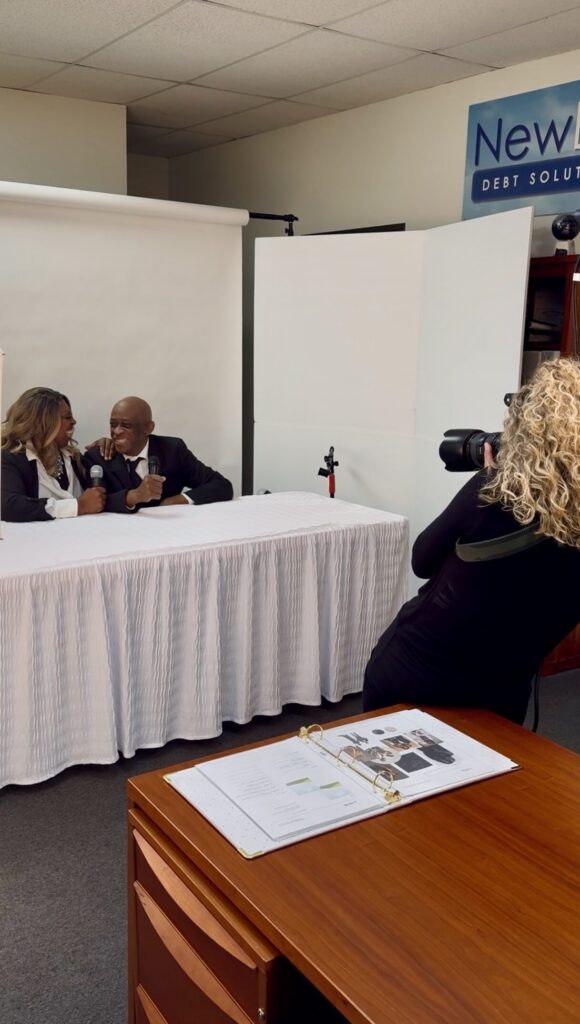 Denise Carter and her husband posing together in formal attire against a white studio background.